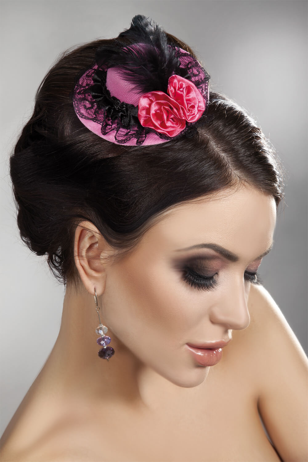 Eleganter Mini Top Hat in Hellrosa mit schwarzen Akzenten, Spitzen und Federn für einen einzigartigen Charme.