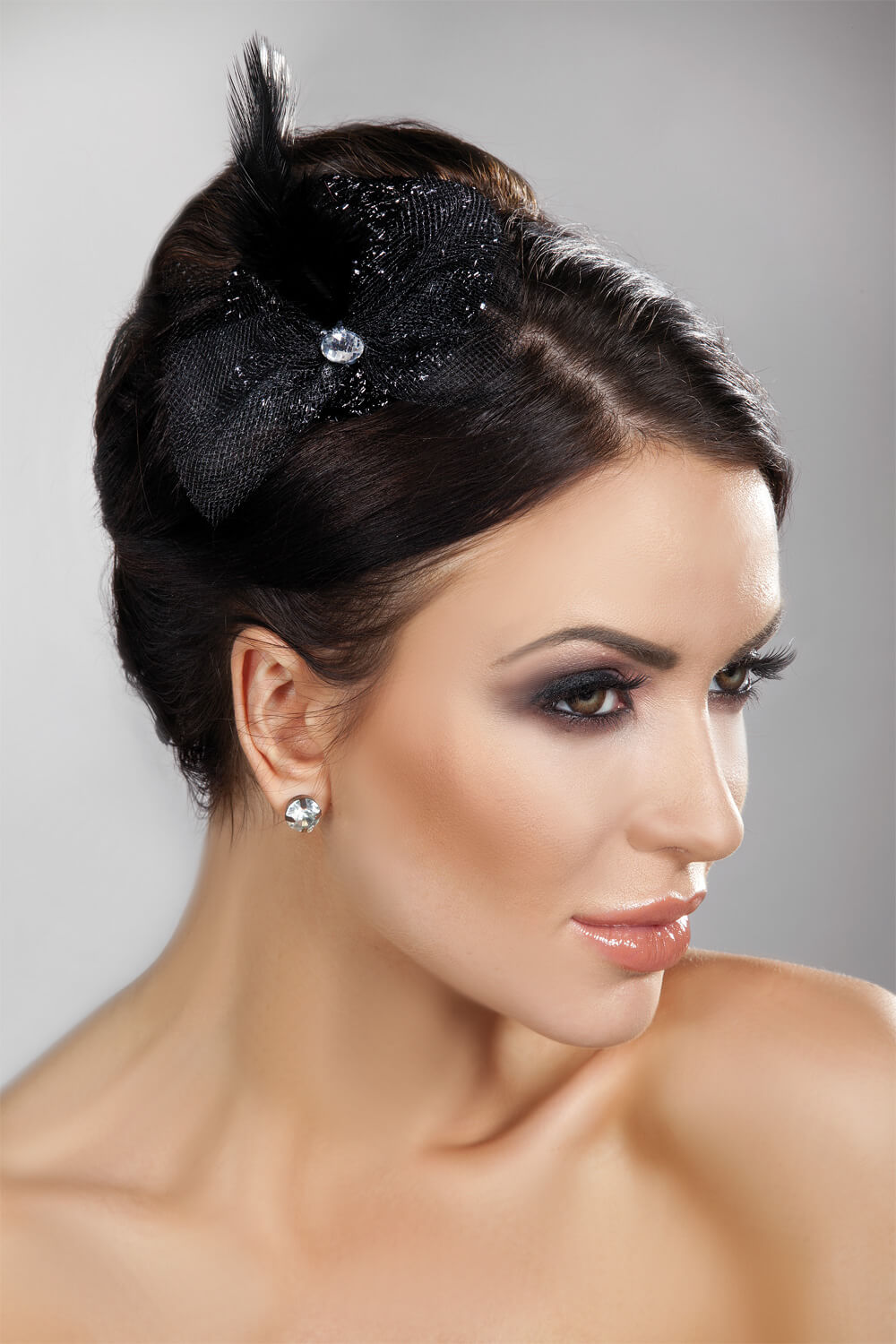 Eleganter Mini Top Hat in Schwarz mit Federn, Steinchen und Schleife – der perfekte Hingucker für besondere Anlässe.